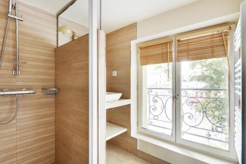 La salle de bains est pourvue d'une douche et d'une fenêtre. dans l'établissement Pick A Flat's Apartment in Saint-Germain - Rue du Bac, à Paris