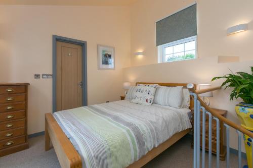 a bedroom with a bed and a window at The Old Well House in Redruth