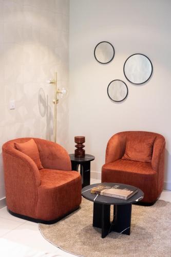 two chairs and a table with mirrors on the wall at The Broadway @The Lennox in Accra