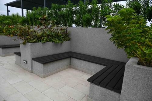 a bench sitting next to a wall with plants at The Broadway @The Lennox in Accra