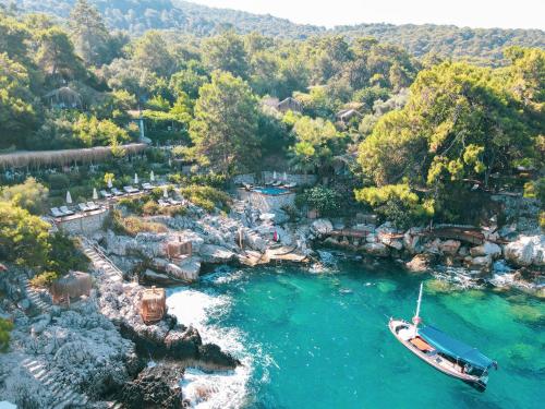 an aerial view of a resort with a boat in the water at Perdue Hotel in Faralya