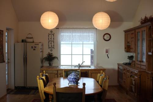 a kitchen with a table and a refrigerator at Charming villa with a hot tub, by the Golden Circle in Reykholt