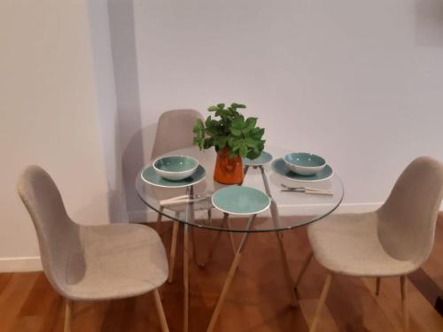 una mesa de cristal con cuatro sillas y una planta en ella en Céntrico y Cómodo departamento VIP, en La Paz