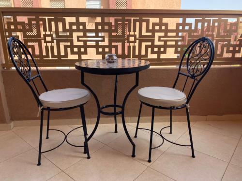 dos sillas y una mesa y una mesa y dos sillas en Charmant Appartement au Cœur de la Ville en Marrakech