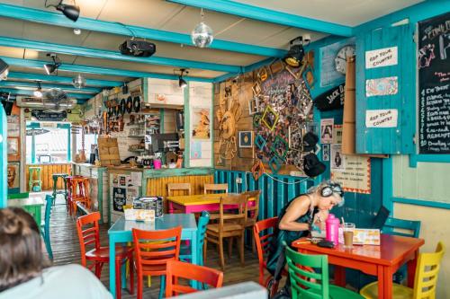 une femme assise à une table dans un restaurant dans l'établissement The Flying Pig Beach Hostel, ages 18 - 40, à Noordwijk aan Zee