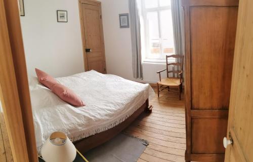 a bedroom with a bed and a chair and a window at Le Clos du Hesdre in Neufchâtel-Hardelot