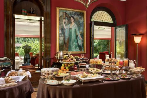 佛罗伦萨Hotel Regency - Small Luxury Hotels of the World的客房内的餐桌上的自助餐