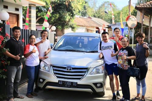 a group of people standing in front of a car at Rumah Ukhi Guest House in Yogyakarta