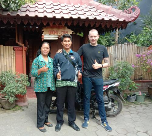 a group of three people standing in front of a house at Rumah Ukhi Guest House in Yogyakarta