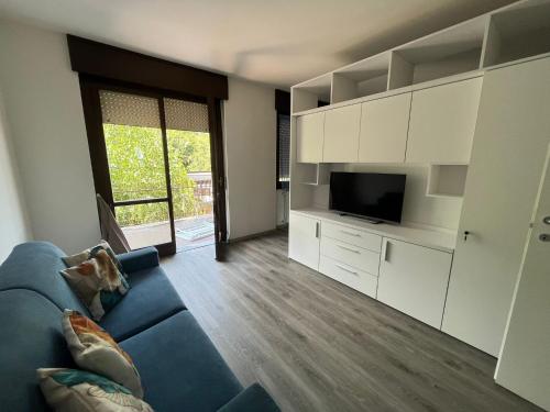 uma sala de estar com um sofá azul e uma televisão em Dream Baveno 2 em Baveno