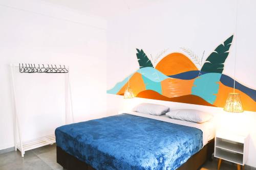 a bedroom with a bed with an orange and blue bedspread at Sea Wolf Hostel - Lagoa da Conceição in Florianópolis