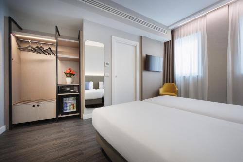 a bedroom with a large white bed and a room at IH Hotels Milano Centrale in Milan