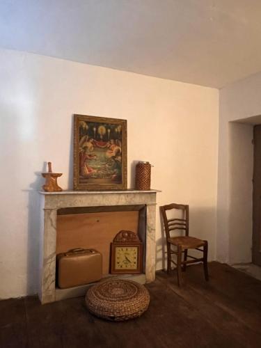 uma sala de estar com lareira e uma imagem na parede em Gite casa mea em Santa-Lucia-di-Mercurio