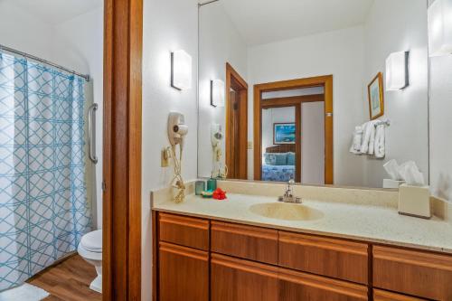 uma casa de banho com um lavatório, um WC e um espelho. em Charming 1br TopFloor Condo in Poipu, Athletic Club 432 em Koloa