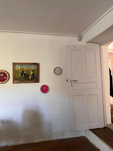 - une porte blanche dans une pièce avec des horloges sur le mur dans l'établissement Gite casa mea, à Santa-Lucia-di-Mercurio