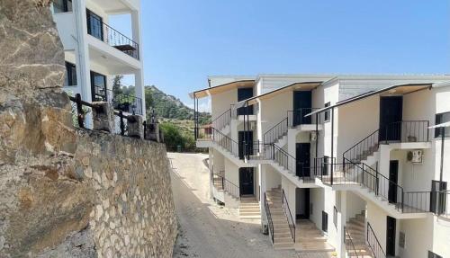 eine Reihe von Gebäuden neben einer Steinmauer in der Unterkunft Öz Akdeniz Apart in Kumluca