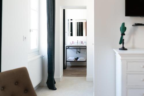 a bathroom with a mirror and a chair in a room at Pavillon des Millésimes, Piscine & SPA in Lussac