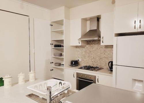 a white kitchen with a sink and a stove at The Elands in Northfield