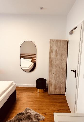 a bedroom with a mirror on the wall and a bed at Pension und Location Cham in Meerbusch