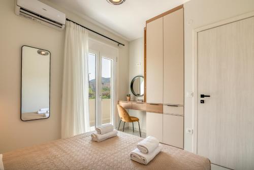 Schlafzimmer mit einem Bett, einem Schreibtisch und einem Spiegel in der Unterkunft Villenia Luxury Apartments in Kissamos