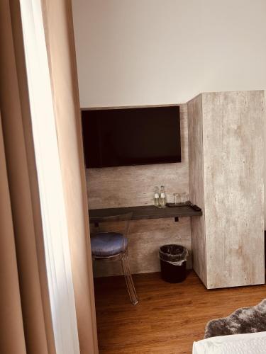 a room with a wall with a television and a stool at Pension und Location Cham in Meerbusch