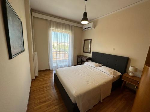 a bedroom with a bed and a window at City View Apartment in Mytilini