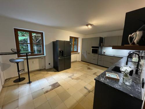 a kitchen with a black refrigerator and a tile floor at Ferienwohnung Bad Reichenhall (Nonn) in Bad Reichenhall