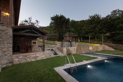 a backyard with a swimming pool and a house at Abraços dos Avós - Casas do Monte in Vila Verde