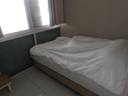an unmade bed in a room with a window at COZY HOUSE Working Space Stay with local in Bangkok Airport in Bangna