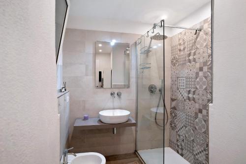 La salle de bains est pourvue d'un lavabo et d'une douche en verre. dans l'établissement Casa Elena, à Bordighera