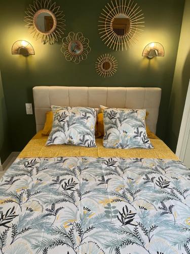 a bed with a blue and white blanket and two mirrors at Bel appartement à Perpignan in Perpignan