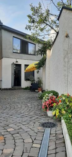 a building with a patio with flowers in front of it at Lux GUEST HOUSЕ МUKACHEVO in Mukacheve
