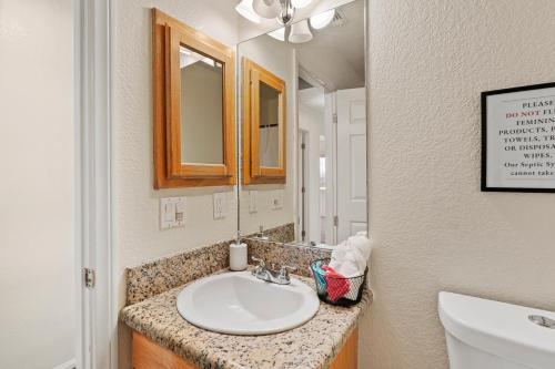 ein Bad mit einem Waschbecken und einem Spiegel in der Unterkunft Cassia Tree in Twentynine Palms