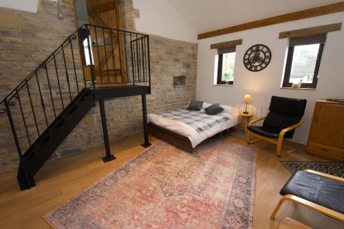 a living room with a staircase and a couch and a chair at The Old Forge in Somerton