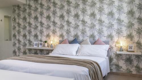 een slaapkamer met een groot bed met bloemenbehang bij Le stanze dei Pico Wi-Fi, Netflix e una terrazza unica sul tetto in Mirandola
