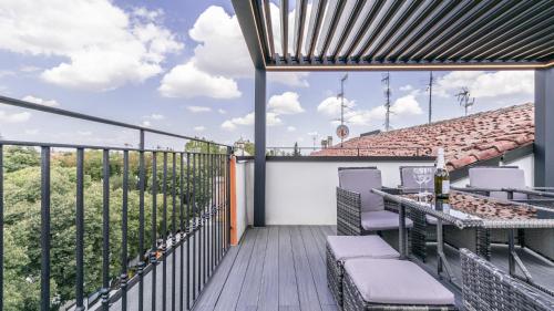 a balcony with a table and chairs on a building at -Le stanze dei Pico- Wi-Fi, nel cuore di Mirandola - una terrazza unica sul tetto in Mirandola