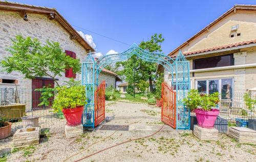 a blue gate with potted plants in a yard at Studio du Daudou piscine jacuzzi partagés in Septfonds