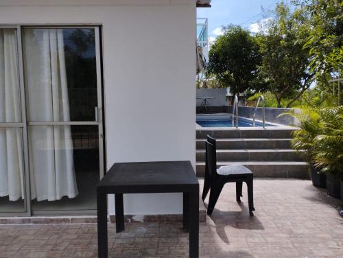 a black table and a chair in front of a house at Apartahotel Eden Coveñas in Coveñas