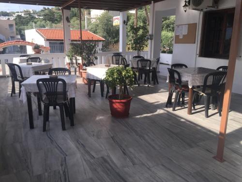 a patio with tables and chairs and a potted plant at Hermes in Kalymnos