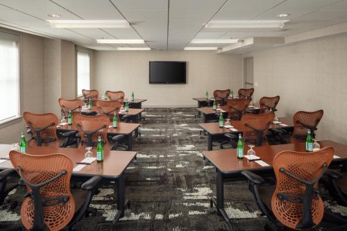 a conference room with tables and chairs and a flat screen tv at DoubleTree Suites by Hilton Hotel Detroit Downtown - Fort Shelby in Detroit