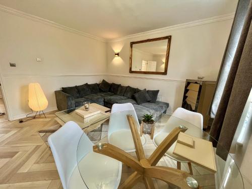a living room with a couch and a table and chairs at Stylish Penarth Marina Apartment in Cardiff
