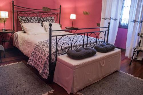 a bedroom with a black bed with two pillows on a bench at caserio vasco con piscina y barbacoa in Orozko