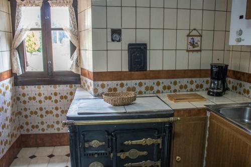 caserio vasco con piscina y barbacoa في Orozko: مطبخ مع موقد قديم ومغسلة