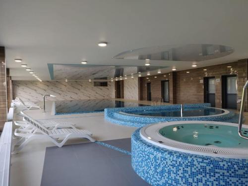 a large room with two hot tubs in a building at Baltic Nest - Dziwnów in Dziwnów