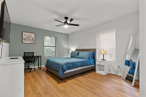 Gainesville-newly remodeled home في غاينيسفيل: غرفة نوم بسرير ومروحة سقف