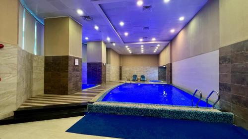 a large swimming pool in a room with a pool at Centaurus Apartment Mountain View Two Beds in Islamabad