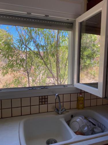 a sink in a kitchen with a window at Strati's beach house in Lakkíon