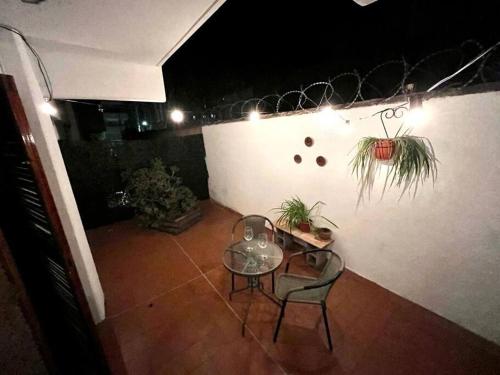 un patio con mesa, 2 sillas y una mesa en Centric cozy apartment with yard en Mendoza