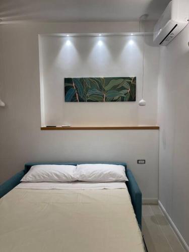 a bed in a room with a painting on the wall at Oleander Apartment in Castellammare di Stabia
