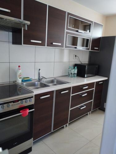 a kitchen with brown cabinets and a sink and a stove at Apartament Agata in Giżycko